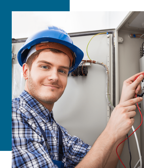 A man in blue shirt and hard hat holding wires.